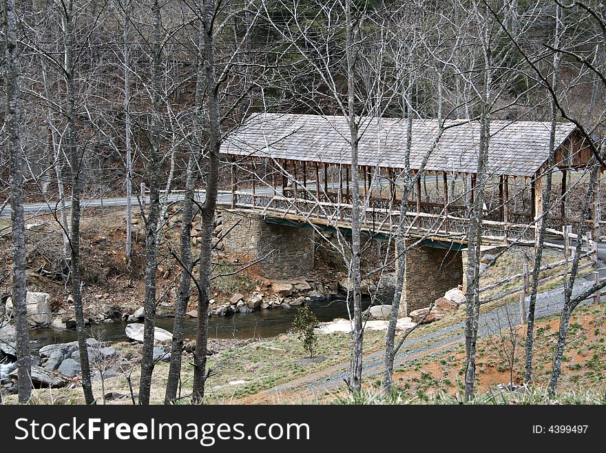 Rustic covered bridge over a river.