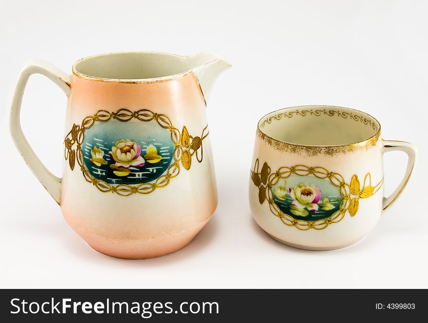 Pitcher with cup on white background