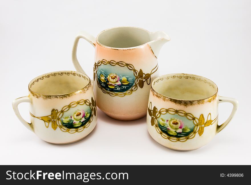 Pitcher with two cups on white background