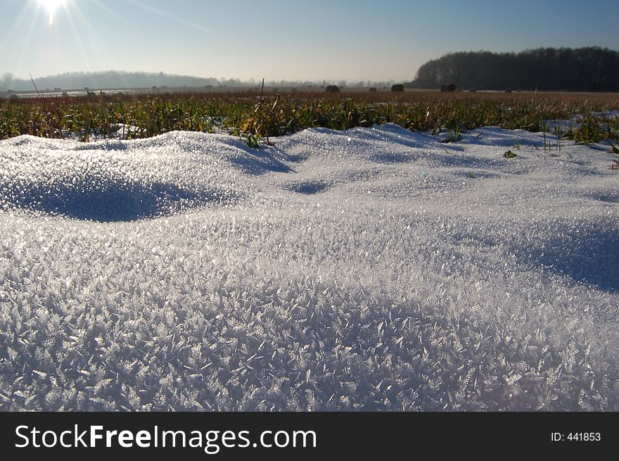 Old snow on the field with the sun