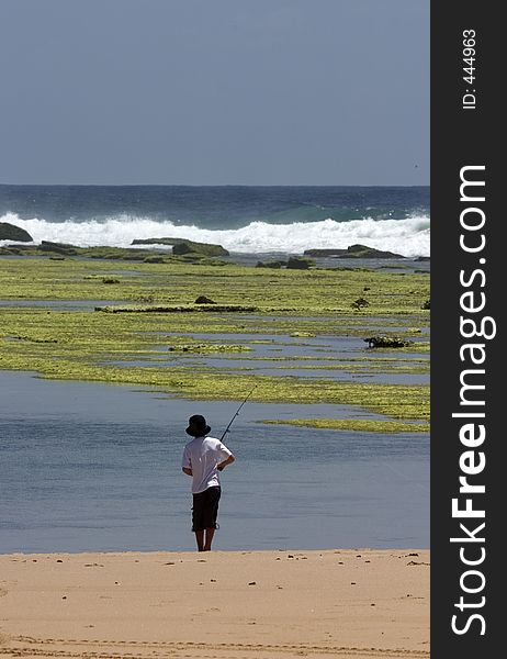 Young boy fishing from beach. Young boy fishing from beach