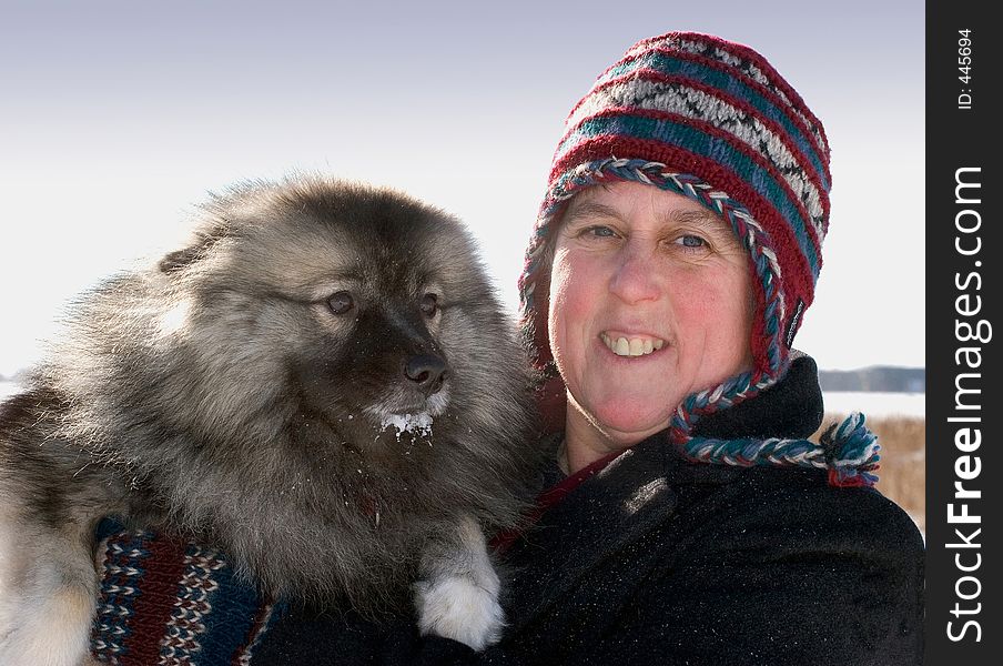 A woman with her dog on a sunny morning after a snow fall. A woman with her dog on a sunny morning after a snow fall