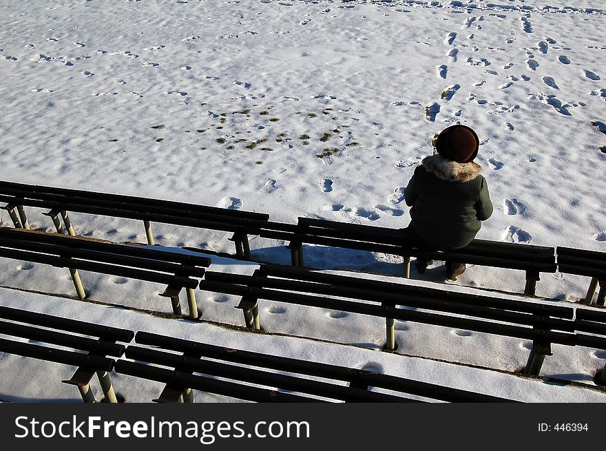 Incognito woman sitting on the bench in winter time