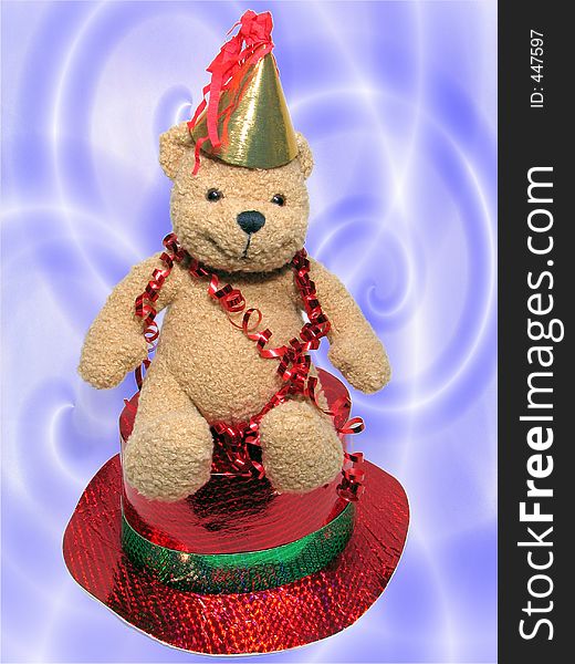Teddy bear with streamer is sitting on a red hat. Teddy bear with streamer is sitting on a red hat.