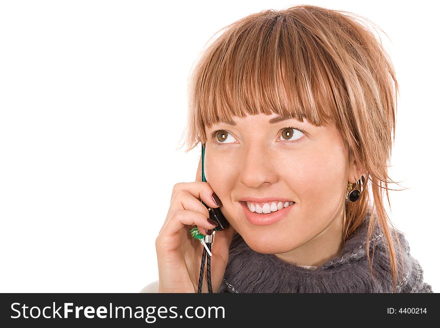 Hello! Attractive young woman call by cellular phone. On the phone hanging little trinket with  soft caramel shape
