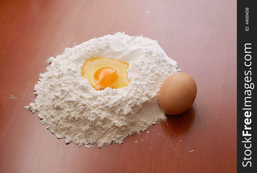 Flour and eggs on wooden table