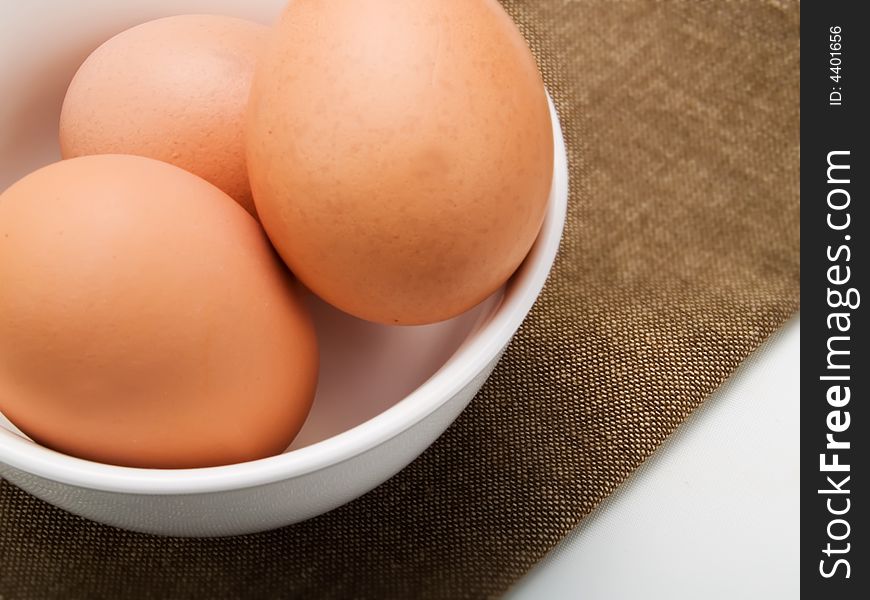 Three eggs in a white bowl