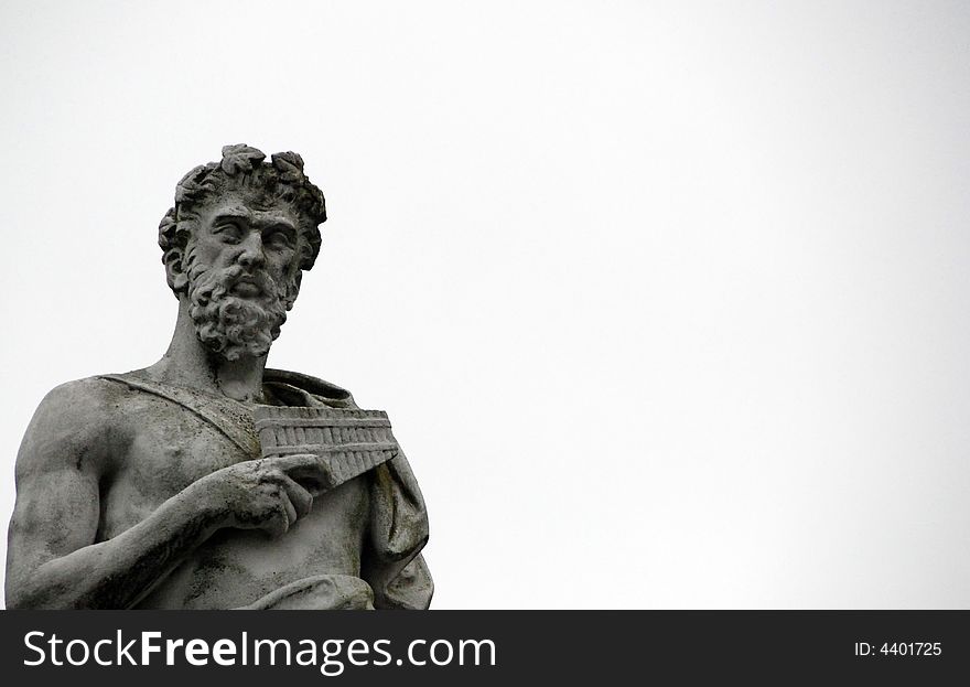 Stone statue of bearded man carrying pan pipes. Stone statue of bearded man carrying pan pipes