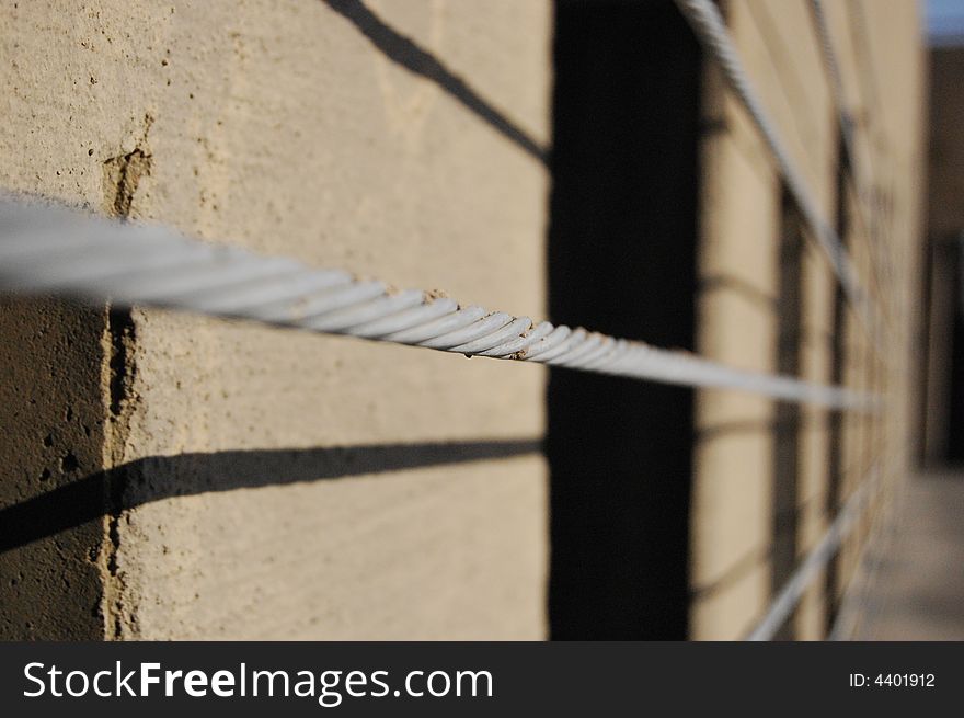 A large cable that is used as a barrier in a parking garage. A large cable that is used as a barrier in a parking garage.