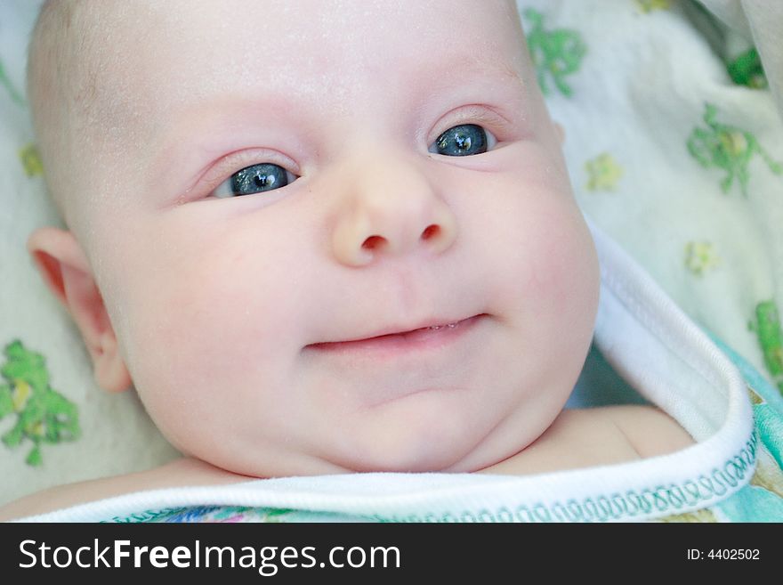 A face of a smiling baby of 2 months old. A face of a smiling baby of 2 months old