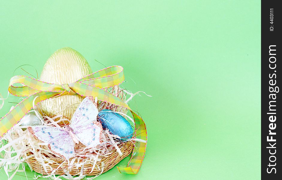 Assortment of chocolate Easter eggs wrapped in colorful paper with butterfly shot on green background. Assortment of chocolate Easter eggs wrapped in colorful paper with butterfly shot on green background