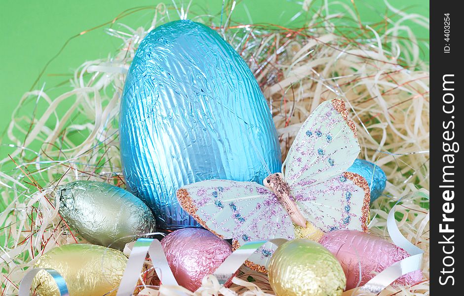 Assortment of chocolate Easter eggs wrapped in colorful paper with butterfly. Assortment of chocolate Easter eggs wrapped in colorful paper with butterfly