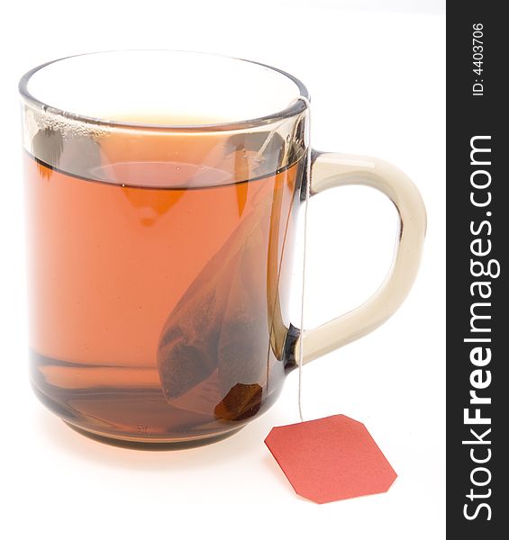 Glass teacup with  tea bag on white background