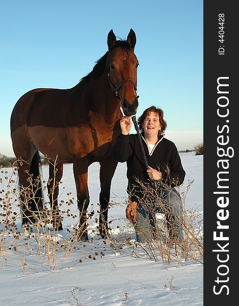 Woman with horse in snowy field in winter. Woman with horse in snowy field in winter.