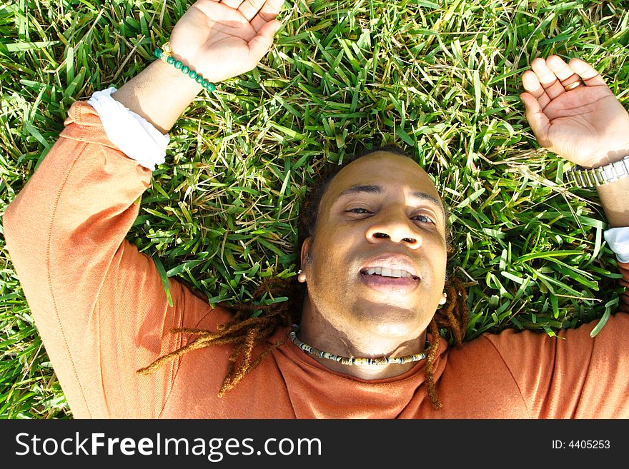 Man lying on the grass and smiling. Man lying on the grass and smiling