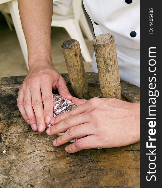 Chef in uniform rolling up food package