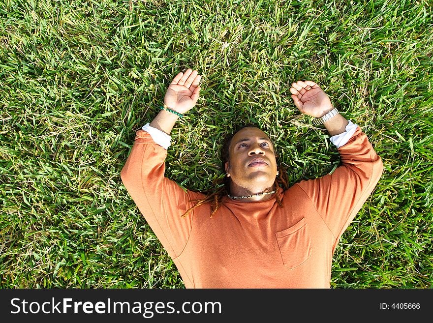 Man lying on the grass and smiling. Man lying on the grass and smiling