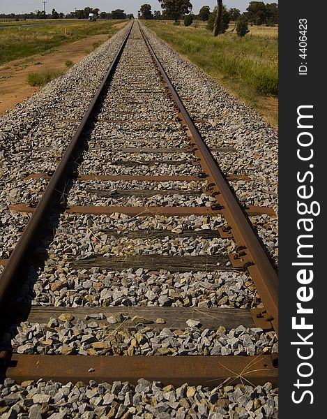 Railway line and truck in country disappearing into distance