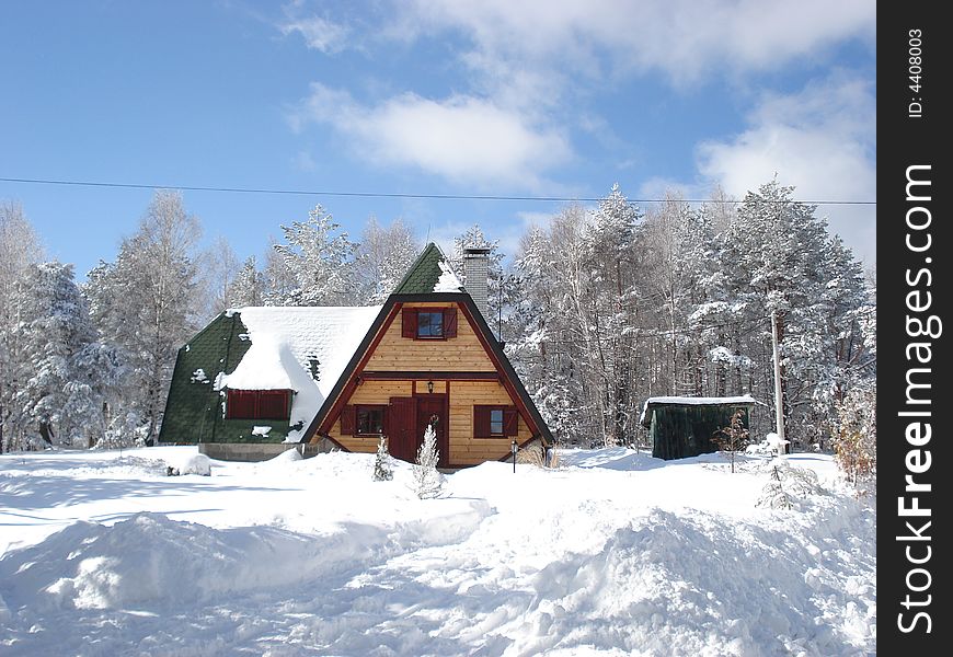 Wooden cottage hidden in the forest between the snow covered pine trees. Wooden cottage hidden in the forest between the snow covered pine trees