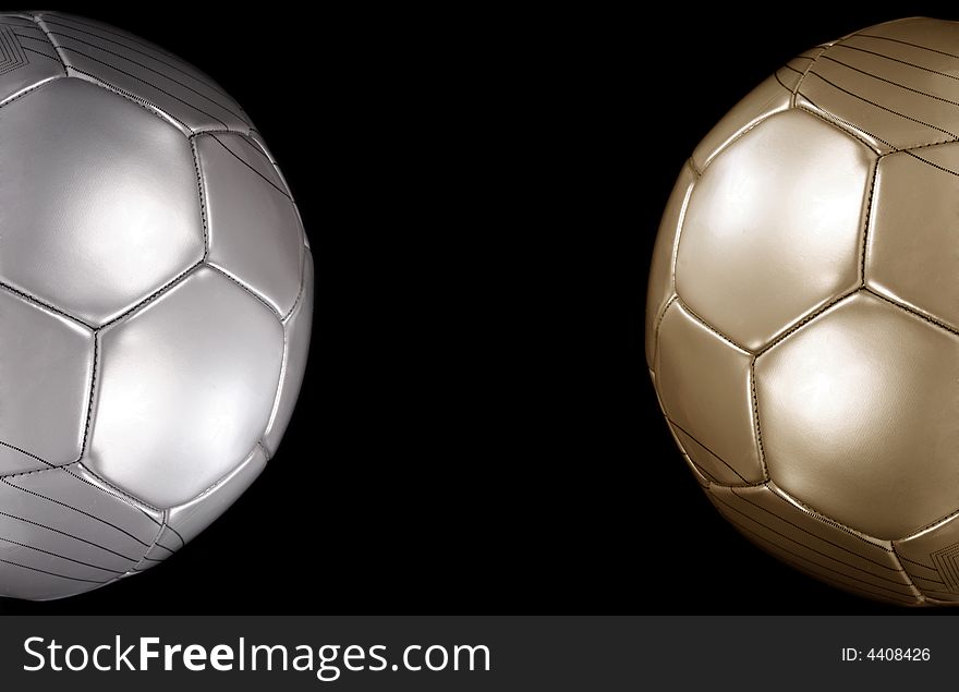 Close up of a gold and silver footballs on black