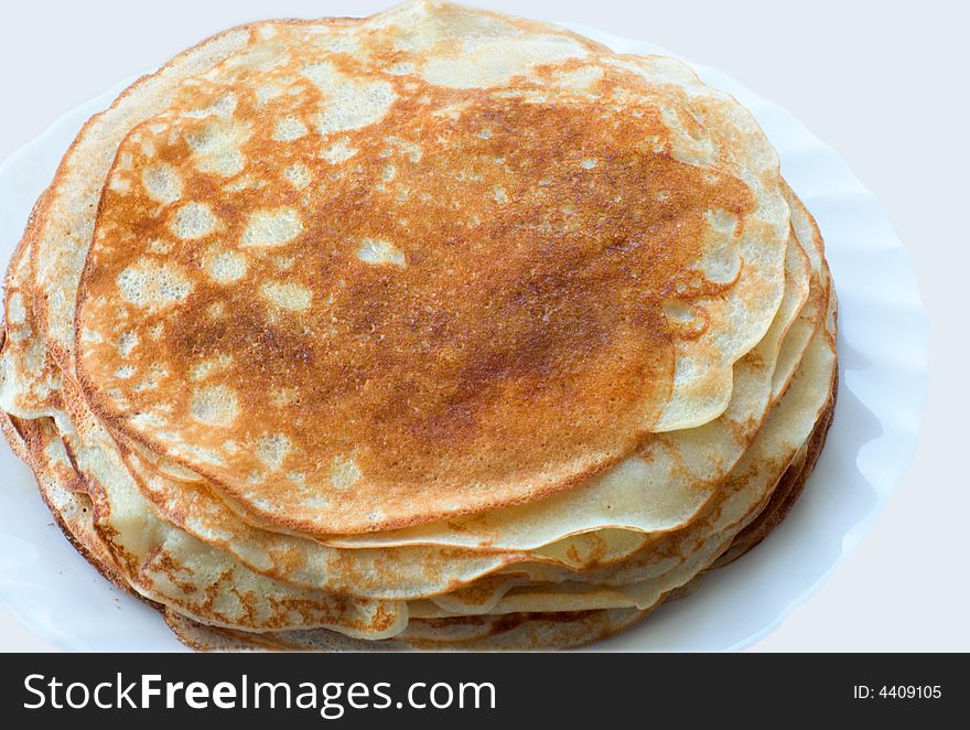 Stack of pancakes in plate on light background