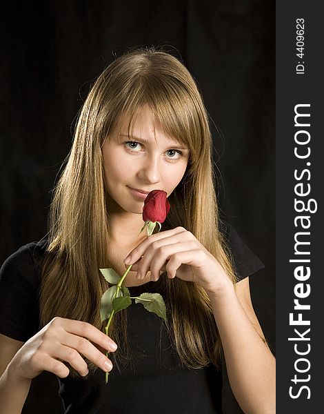 Portrait of young woman with red rose