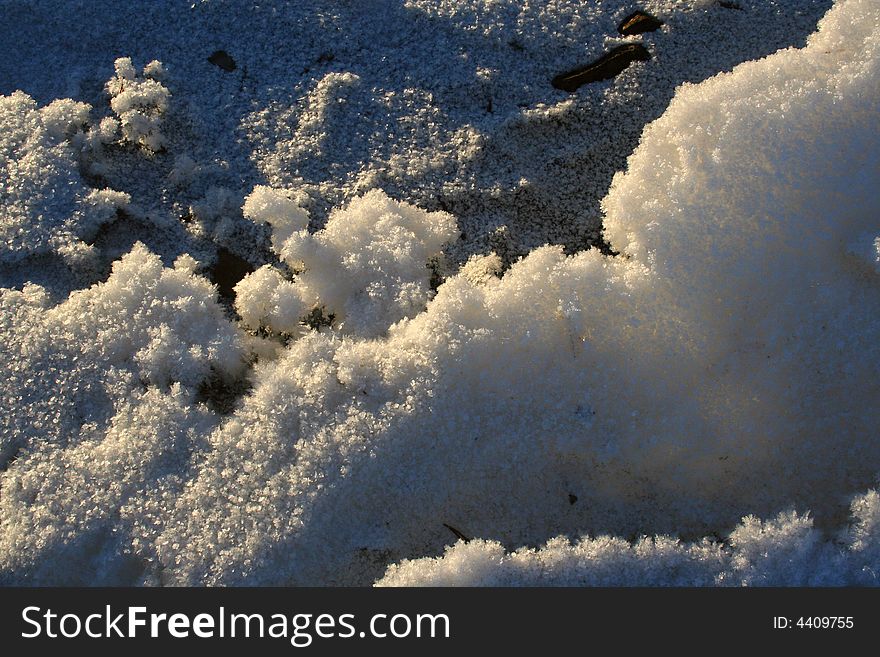 Friable snow in the sunlight and shadows