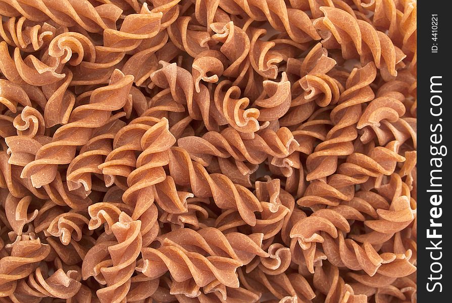 Unrefined Fusilli pasta as a background. Unrefined Fusilli pasta as a background