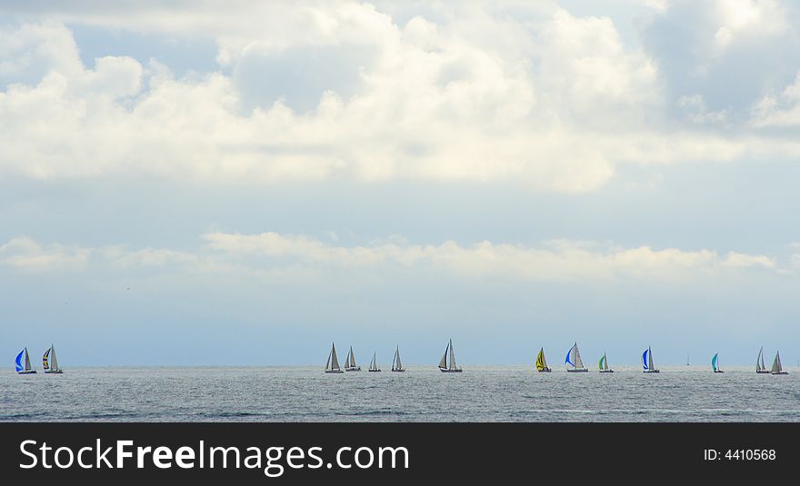 Yachts race in the mediterranean sea under a cloudy sky