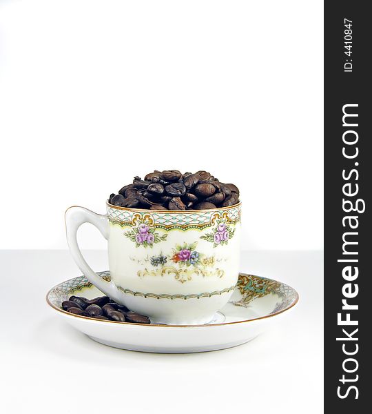 Coffee beans in and antique cup and saucer. Coffee beans in and antique cup and saucer.