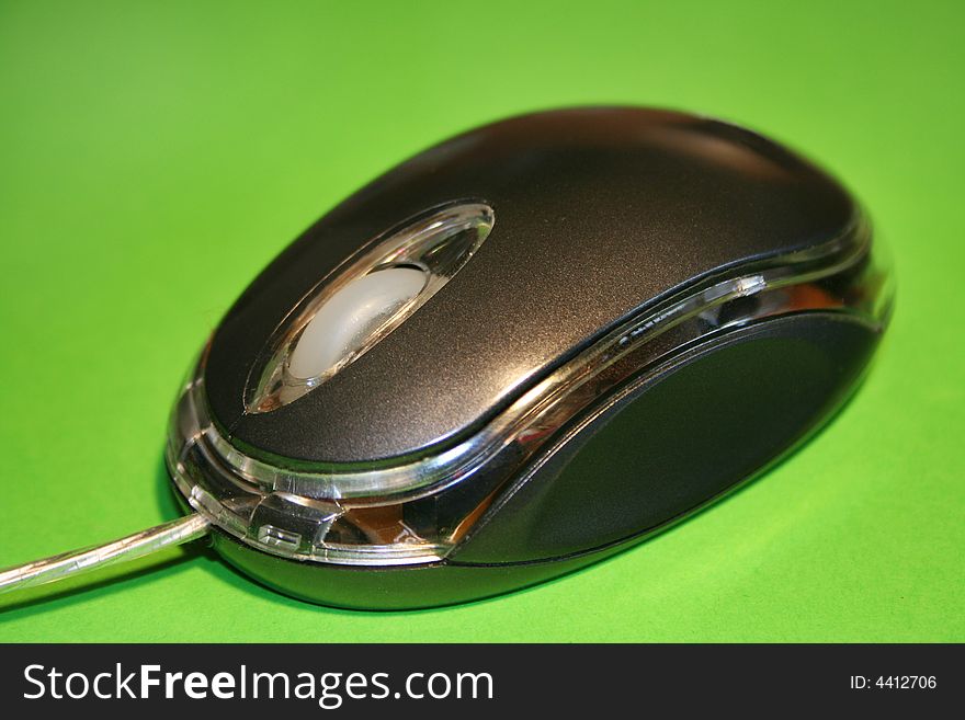 Optical computer mouse on a green background with selective focus