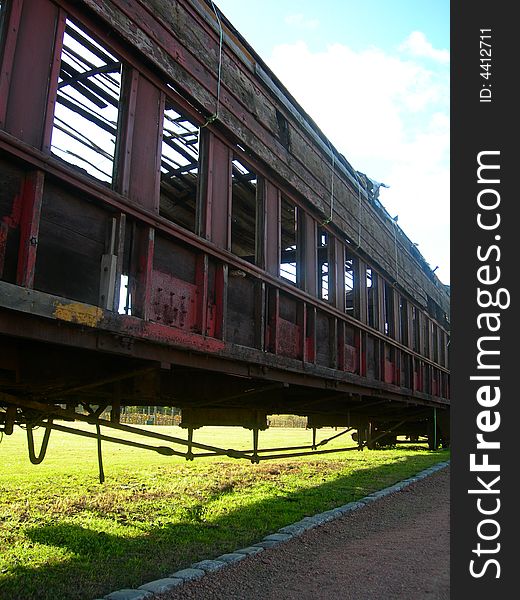 Old and oxide train wagon in the countryside, with the sky background