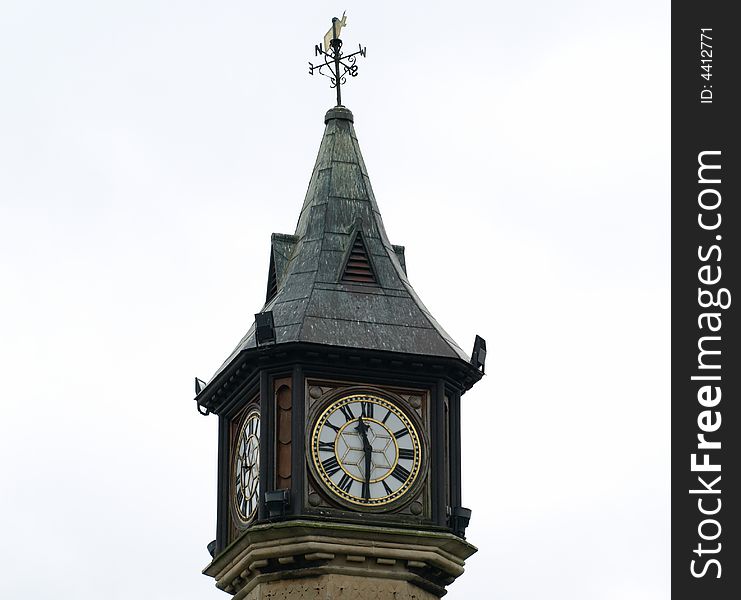 Clock in a tower with a spire. Clock in a tower with a spire