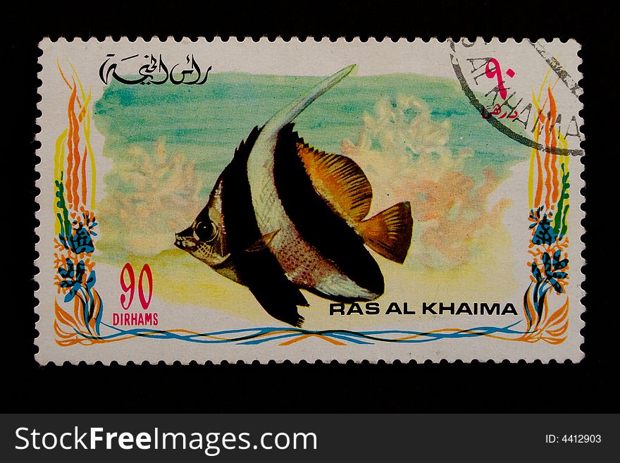 Used old stamp with fish on a black background