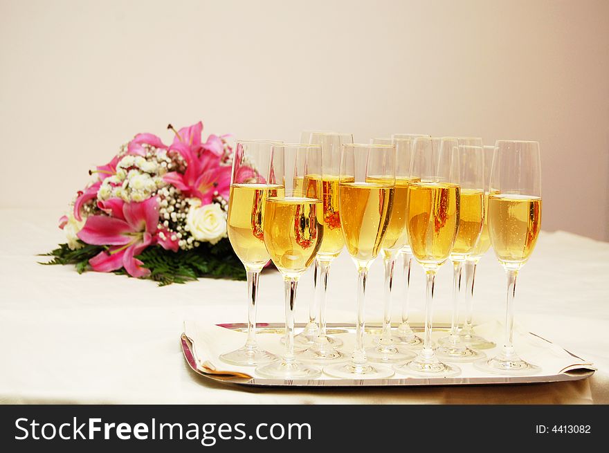Several glasses of champagne with flower decoration on the table. Several glasses of champagne with flower decoration on the table