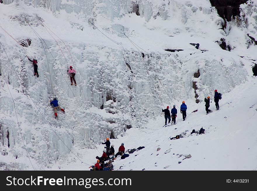 A group of  people ice climbing on mountian side. A group of  people ice climbing on mountian side