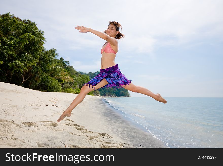 Young woman jumping happily at the beach. Young woman jumping happily at the beach