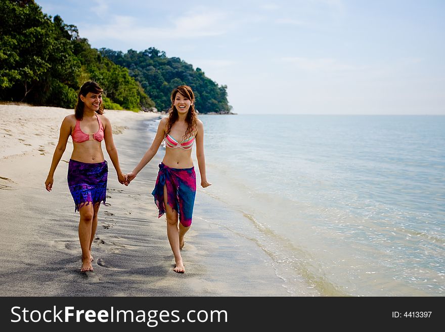 Two girls strolling by the beach. Two girls strolling by the beach