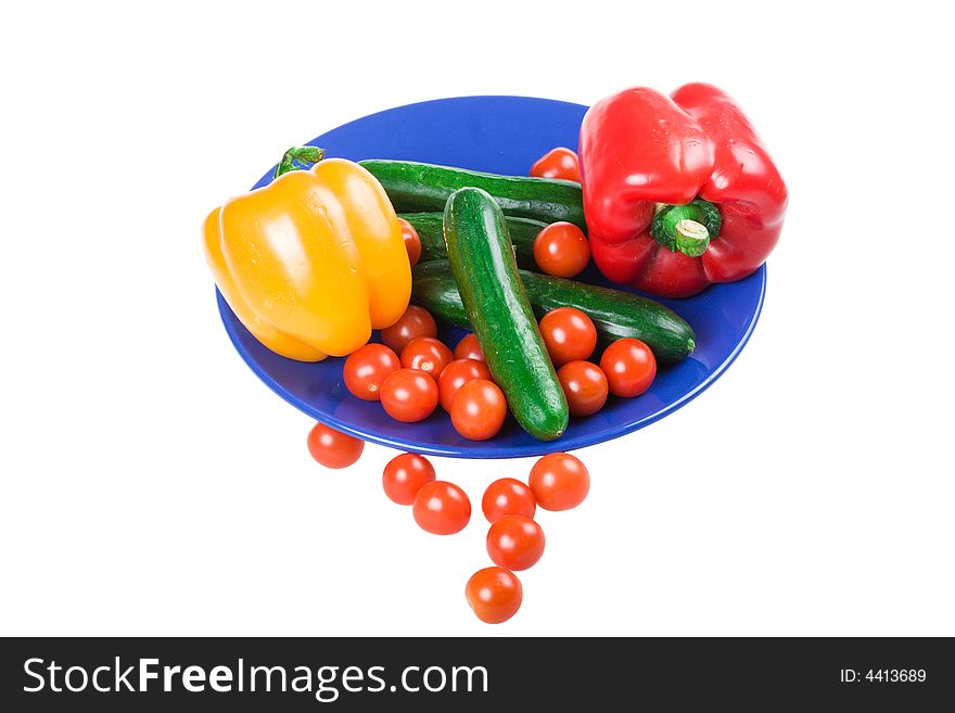 Set of vegetables on a dark blue plate isolated on a white background