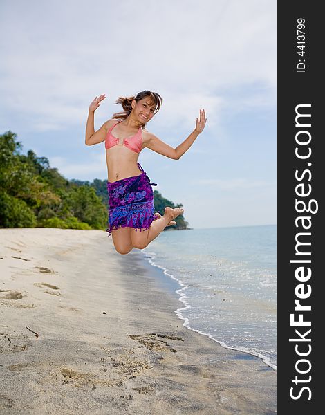 Young woman jumping happily at the beach. Young woman jumping happily at the beach