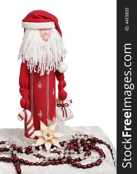 Toy Santa figurine holding a candycane and gift with decorations below.