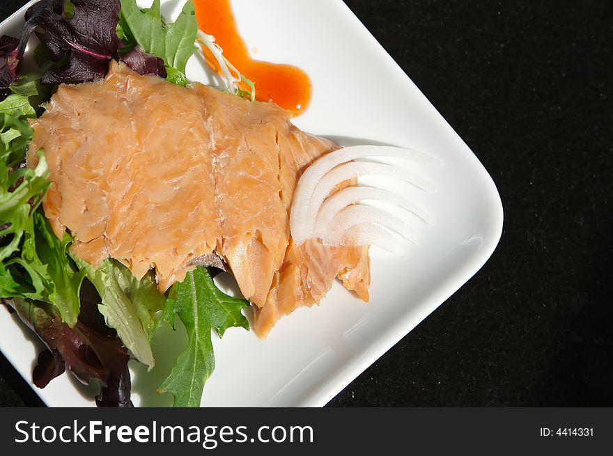 Alaskan smoked sockeye salmon starter on a bed of lettuce