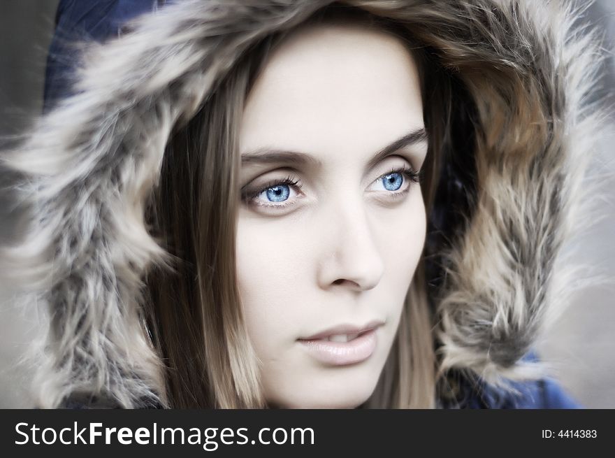 Portrait of a beautiful blue eyed young woman with a hood. Portrait of a beautiful blue eyed young woman with a hood
