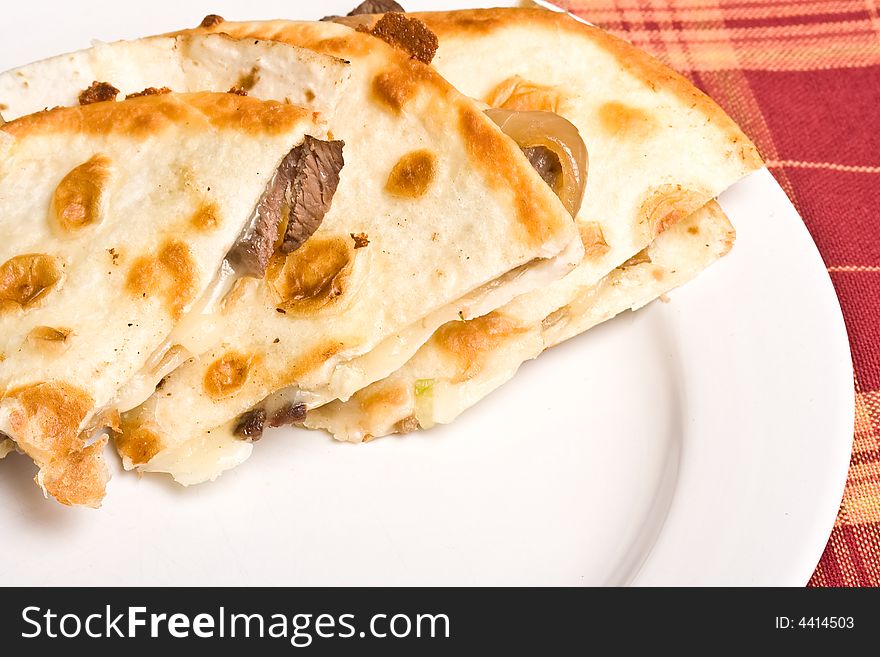 Fresh off the stove a steak Quesadilla on a white plate