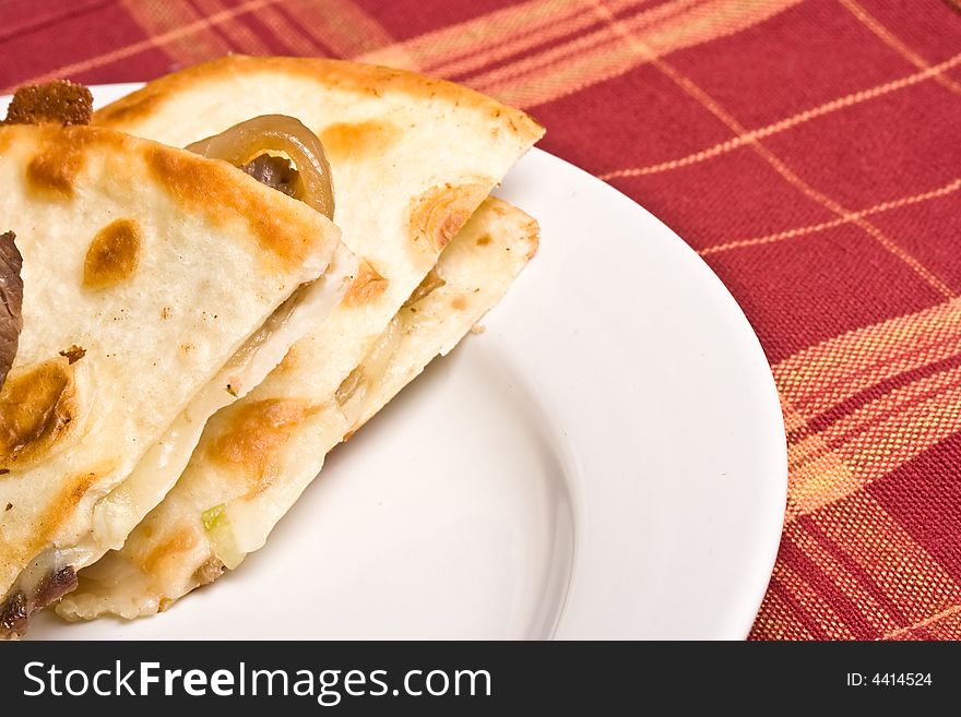 Fresh off the stove a steak Quesadilla on a white plate