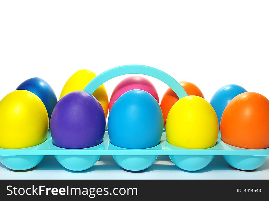 Easter holiday. Color eggs in a tray on white  background.