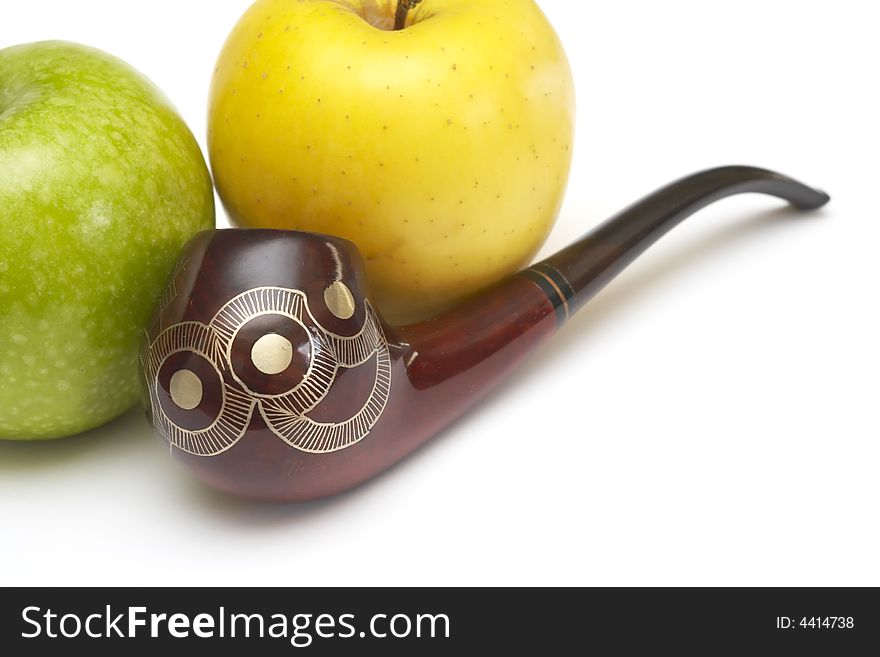 Close-up of long ornamented north-caucasian pipe with multicolored apples at white background. Close-up of long ornamented north-caucasian pipe with multicolored apples at white background