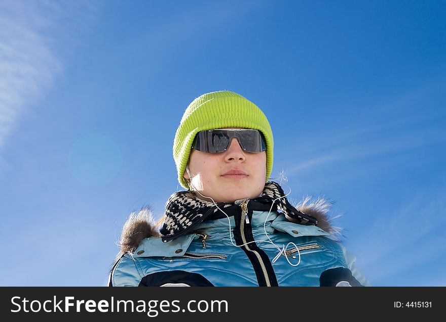 The girl with headphones on a background of the blue sky