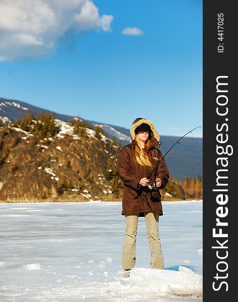 Young blonde girl is skating on a frozen lake