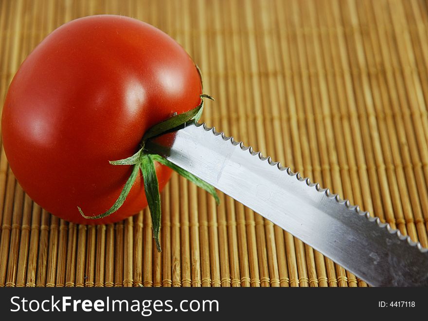 a fresh red tomatoes with a knife